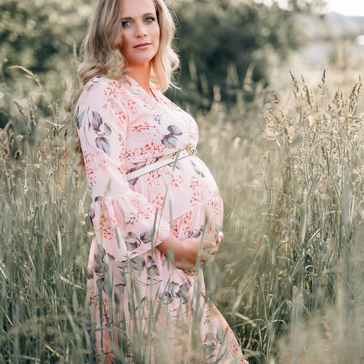 babybauch shooting im feld mit rosa kleid