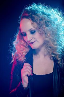 frau mit locken im studio blaues licht