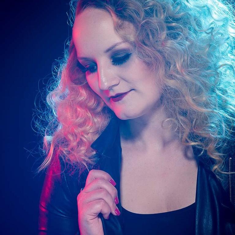 frau mit locken im studio blaues licht