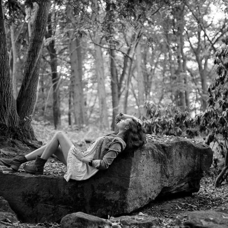 frau im wald liegend auf stein