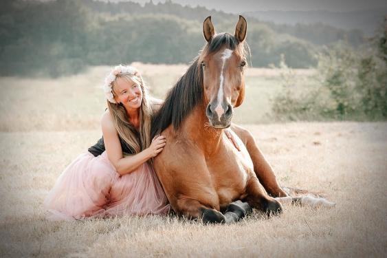 frau mit oferd liegend wiese