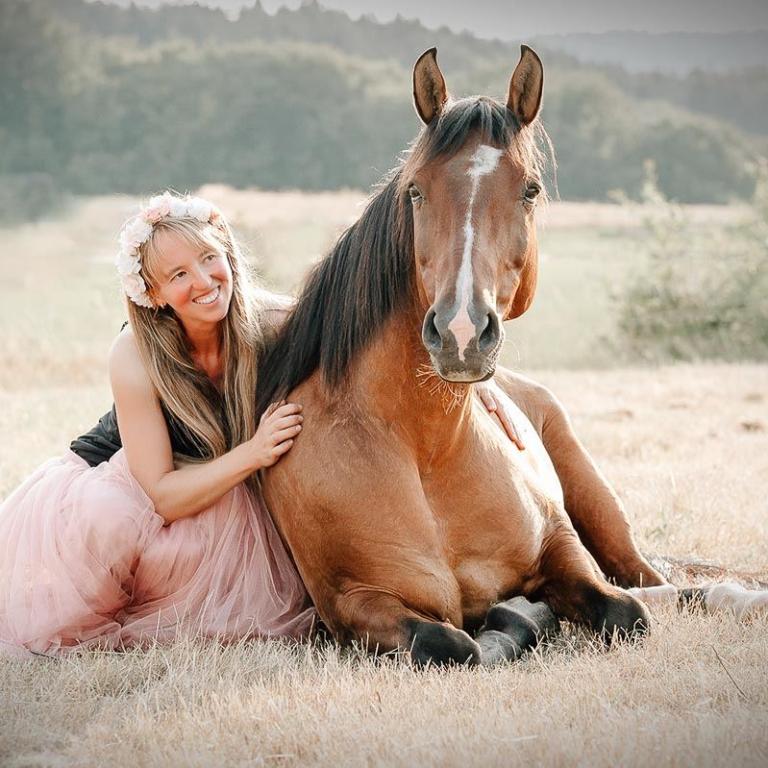 frau mit oferd liegend wiese